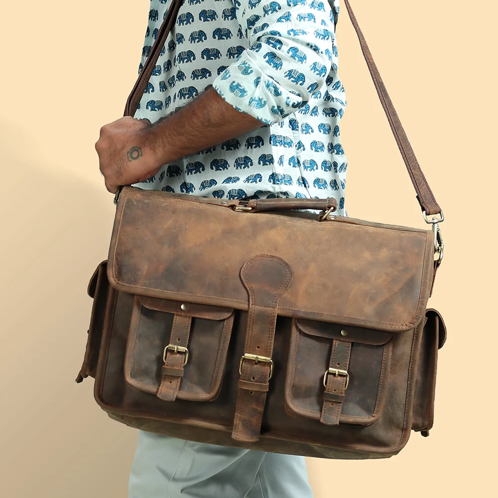 Men's leather messenger bag with front buckle pockets, worn cross-body