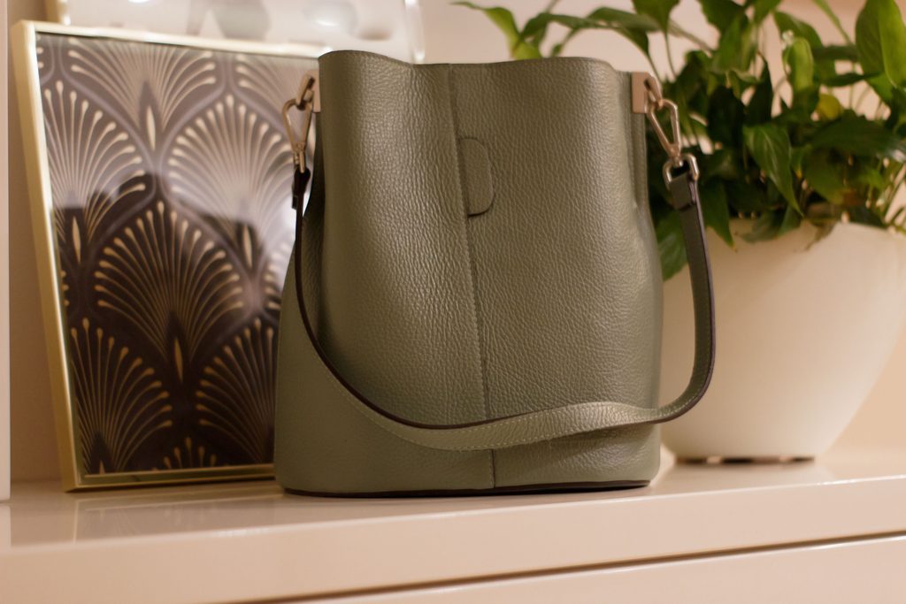 Olive-green leather handbag with a timeless design and textured finish.