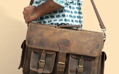 Men's leather messenger bag with front buckle pockets, worn cross-body
